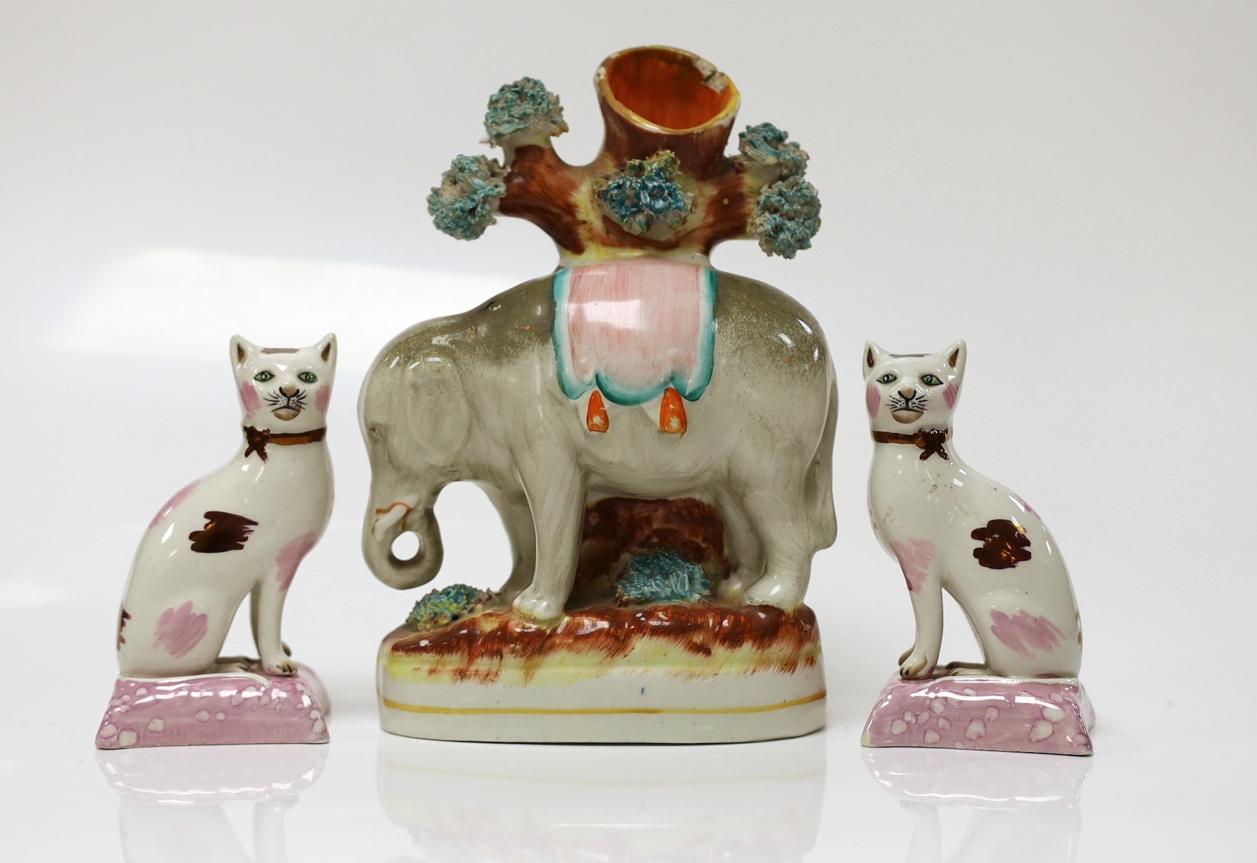 A Staffordshire elephant spill vase and a pair of cats, elephant 17cms high